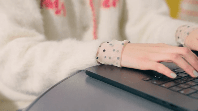 Woman typing on a laptop keyboard