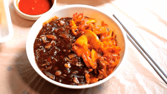 테이블 위에 떡이 들어간 짬짜면 한그릇