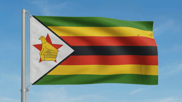 Zimbabwean flag waving against a clear sky