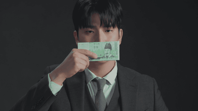 돈으로 입을 가리고 있는 남자