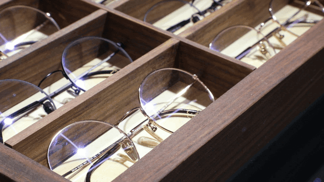 Display of various eyeglasses in a wooden case