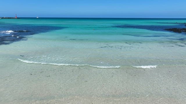 맑은 푸른 물이 있는 고요한 해변