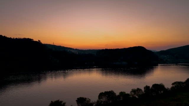 Red Sunset over a Serene Riverside Town