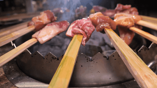 Primitive raw skewers grilling over brazier