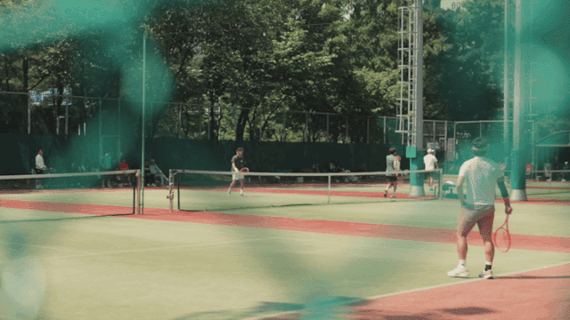 야외 코트에서 테니스 치는 사람들