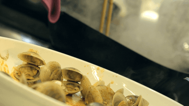 Steaming clams in a white dish