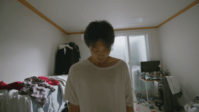 어수선한 방에 있는 젊은 남성