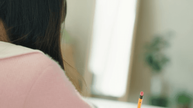 Young girl resting her head on the table after studying