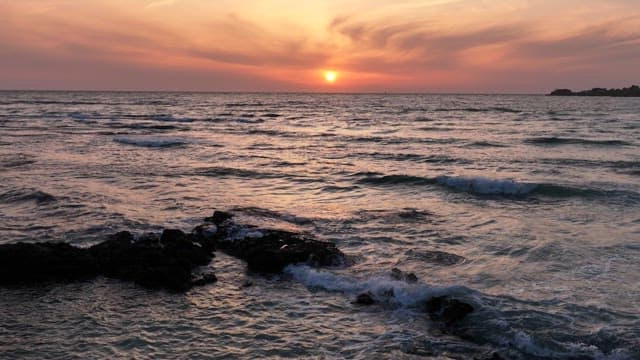 Sunset over the ocean with gentle waves