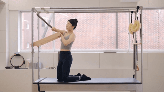 Woman adjusting pilates equipment indoors