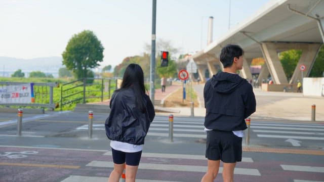 횡단보도에서 기다리며 준비운동을 하는 사람들