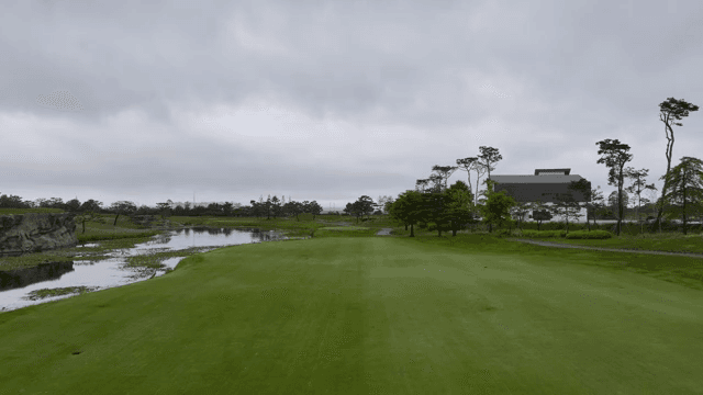 A serene golf course with a pond and trees