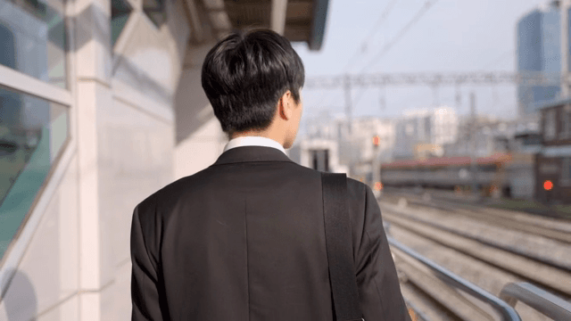 지하철역 플랫폼에서 걷는 직장인 남성의 뒷모습