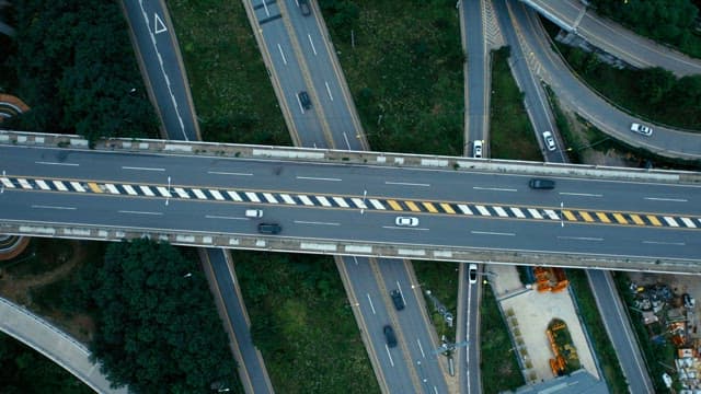 여러 대의 차들이 지나가는 고속도로와 고가도로