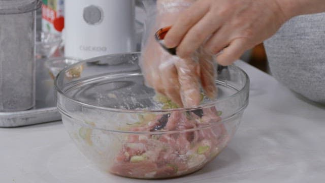 Marinating meat with seasoning in a glass bowl