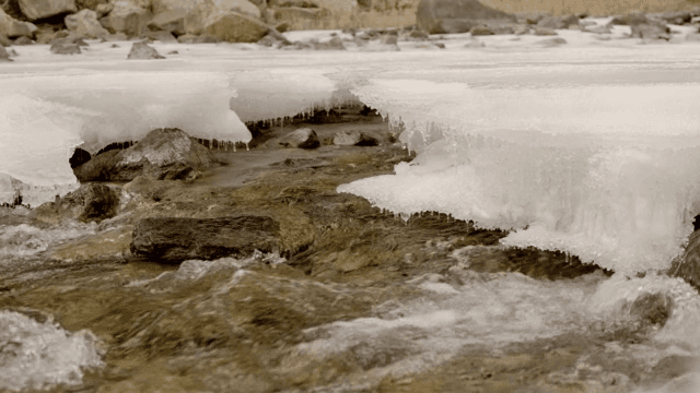 Flowing river with ice and rocks