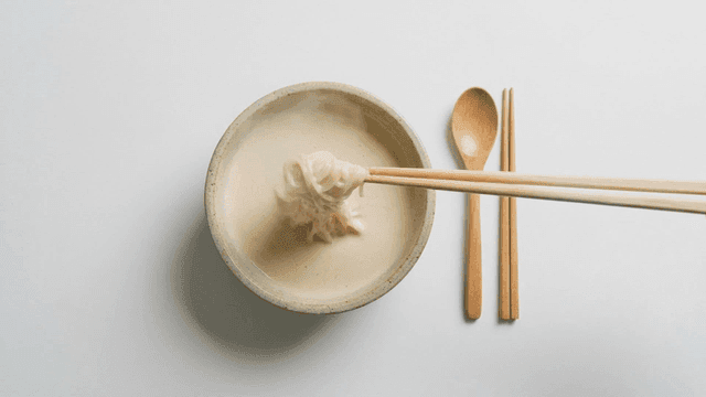 A bowl of noodles in creamy broth