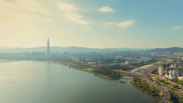 A sprawling cityscape with a river and stadium