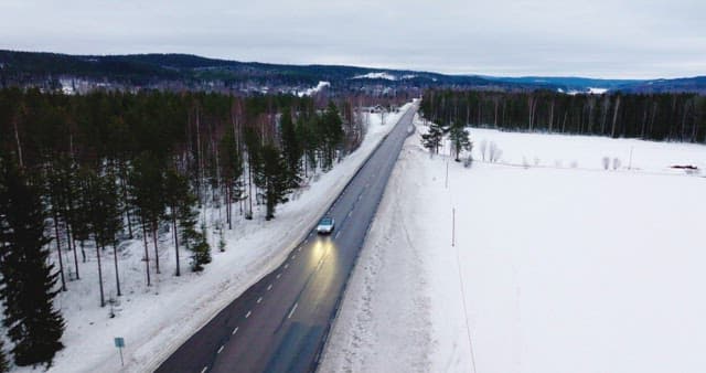 Car driving on a snowy forest road