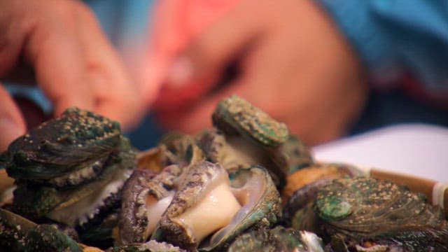 Fresh abalone stacked on a wooden tray