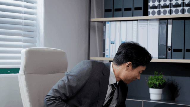 A man rising with a smile after looking at his smartphone