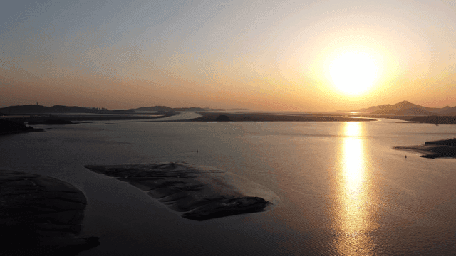Sunset over calm sea in distance