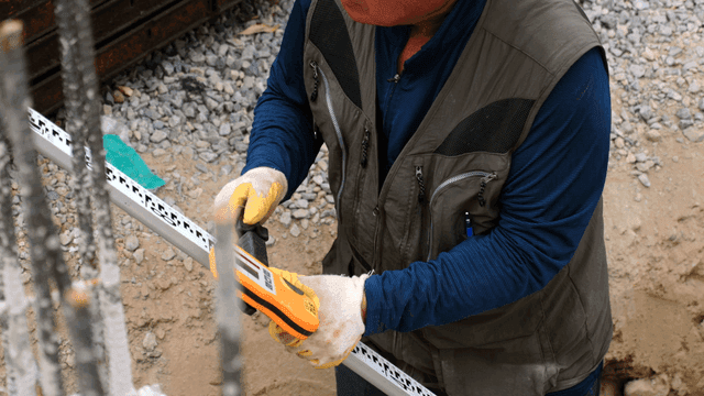 Worker using a measuring tool at a site