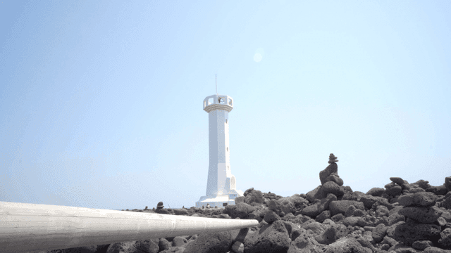 White lighthouse surrounded by rocky terrain