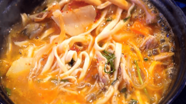 버섯 칼국수를 젓가락으로 젓는 모습