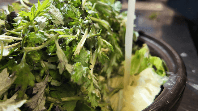 Broth poured into pot filled with fresh mugwort