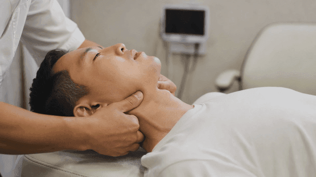 Man receiving neck massage at clinic.