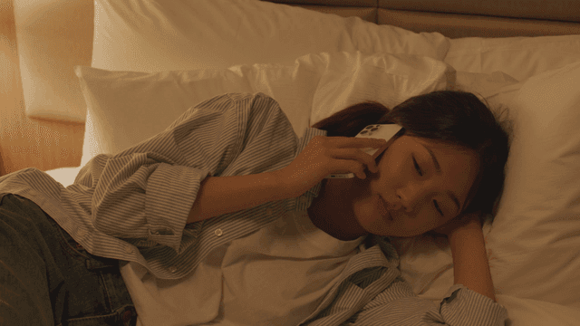 Woman talking on the phone while lying in bed