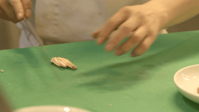 Chef cutting ginseng on cutting board