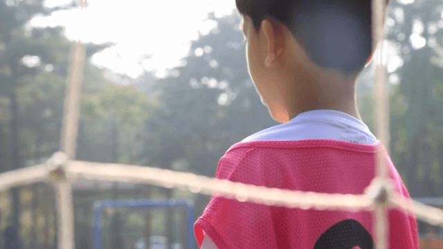 축구장 위에 서있는 핑크색 유니폼을 입은 아이