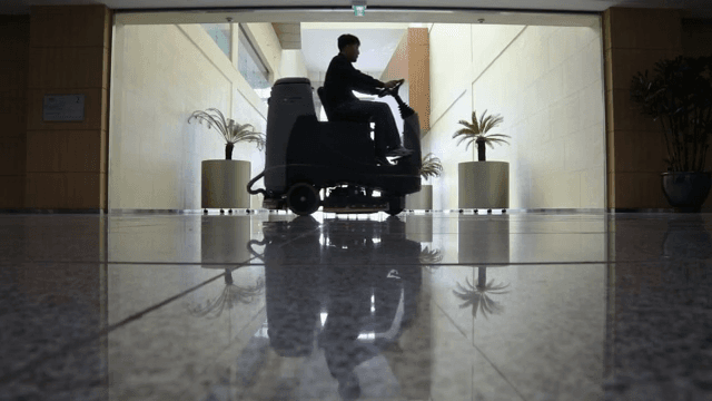 반짝이는 복도 바닥을 청소하는 사람