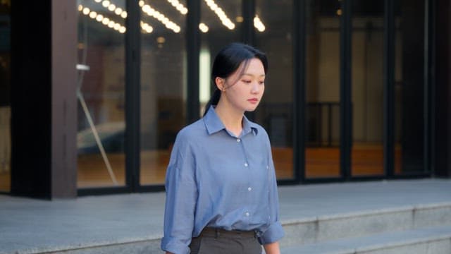 건물 밖에서 위를 바라보는 여성