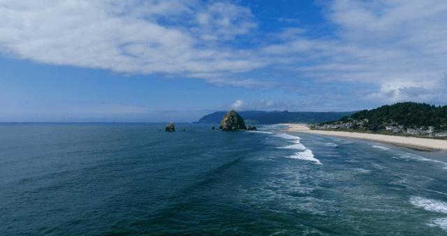 A serene beach with waves and rocky formations