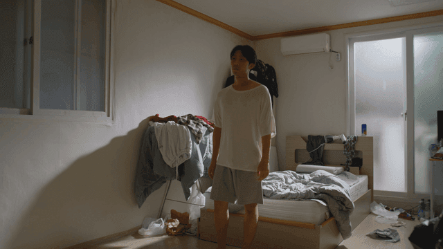 지저분한 침실에 서 있는 남자