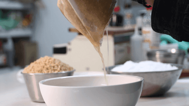 Dish where minced garlic juice is squeezed out using cheesecloth in kitchen.