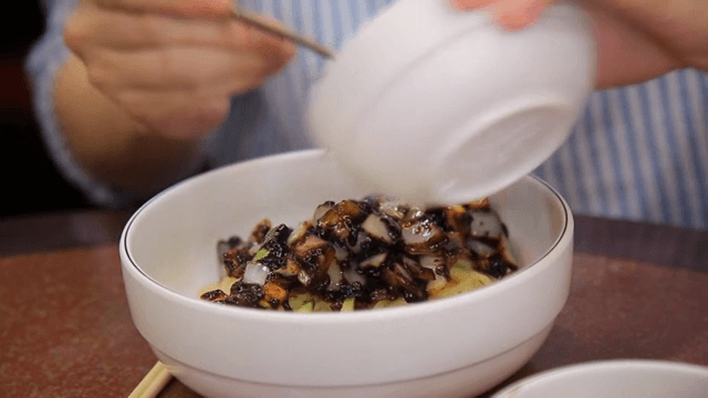 짜장면 소스를 면 위에 붓는 장면