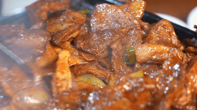 Spicy stir-fried pork sizzling on hot plate