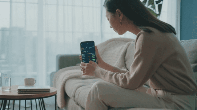 Woman viewing stock data on smartphone