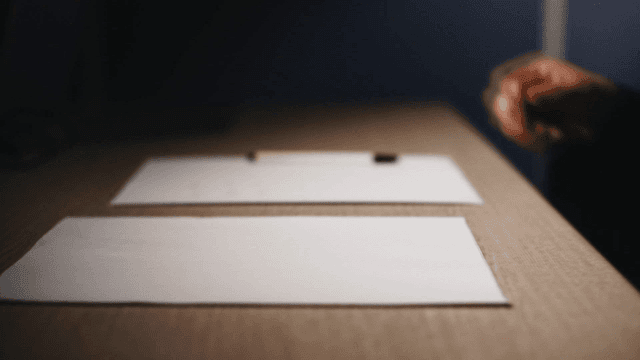 Person handing over documents at desk