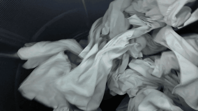 White laundry spinning in large washing machine