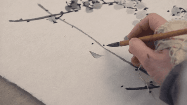 붓으로 종이에 그림을 그리는 손