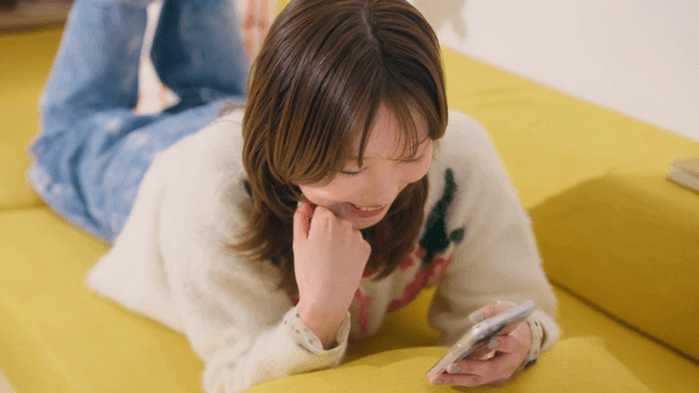 소파에서 스마트폰을 사용하는 여성