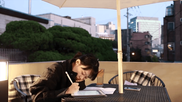 테라스에서 테블릿으로 공부하는 여성