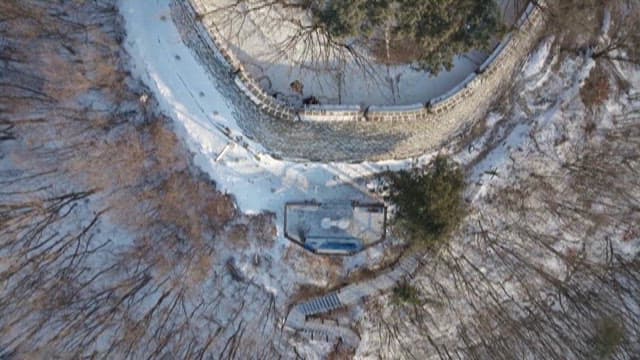 눈이 내린 숲 가운데 있는 고대 성벽