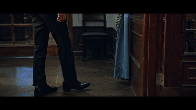 Back view of person walking in dark, classic room