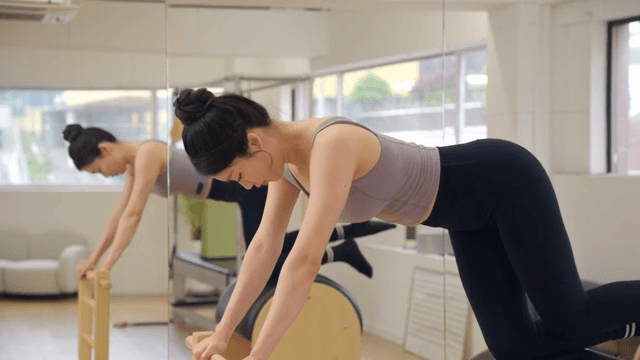 Woman exercising on a pilates barrel